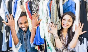 Young multiracial couple having fun at clothing flea market